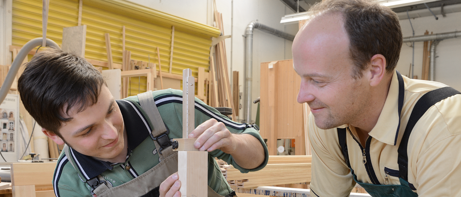 Mensch, Mann, Lehrling, Azubi, Meister, Chef, Auszubildender, zeigen, Fenster, Einbau, Einbau von genormten Baufertigteilen, Handwerk, Fensterrahmen, Rahmen, Holz, Maschine, Werkstatt, anfertigen, einbauen, Glas, Glaser, Fensterbau, Glasfassadenbau, Verglasung, Glasbau, Fensterbauer, messen, ausmessen, abmessen, Schreiner, Tischler 14226