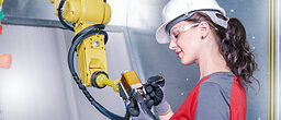 A young female technician while machine constructing in a manufacturing plant Schlagwort(e): automation, checking, construction, consultant, contractor, control, digital, engineer, engineering, engineers, equipment, factory, female, germany, hardhat, industrial, industry, machine, machine constructing, machinery, maintenance, manufacture, manufacturing, manufacturing plant, mechanic, mechanical, metal, occupation, person, planning, plans, plant, production, protective, robot, robotic, robotic arm, safety, service, steel, support, technician, technology, woman, work, worker, working, automation, checking, construction, consultant, contractor, control, digital, engineer, engineering, engineers, equipment, factory, female, germany, hardhat, industrial, industry, machine, machine constructing, machinery, maintenance, manufacture, manufacturing, manufacturing plant, mechanic, mechanical, metal, occupation, person, planning, plans, plant, production, protective, robot, robotic, robotic arm, safety, service, steel, support, technician, technology, woman, work, worker, working, cobot, coboter, Messe, Online, Online-Messe, Kollege, Roboter