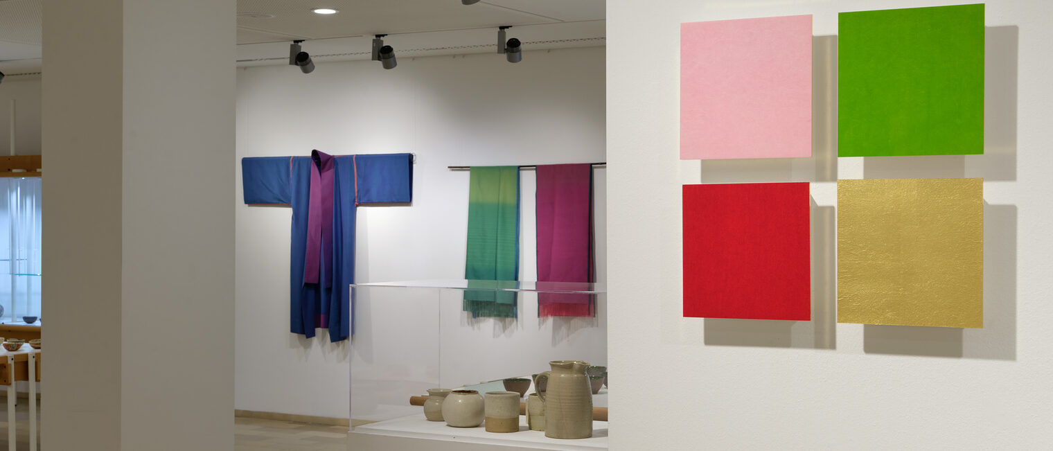 Objekte und Textilien von Renate Balda und Maya Vogl. Bunte Textilien, grafisch angeordnet und Tongefäße
