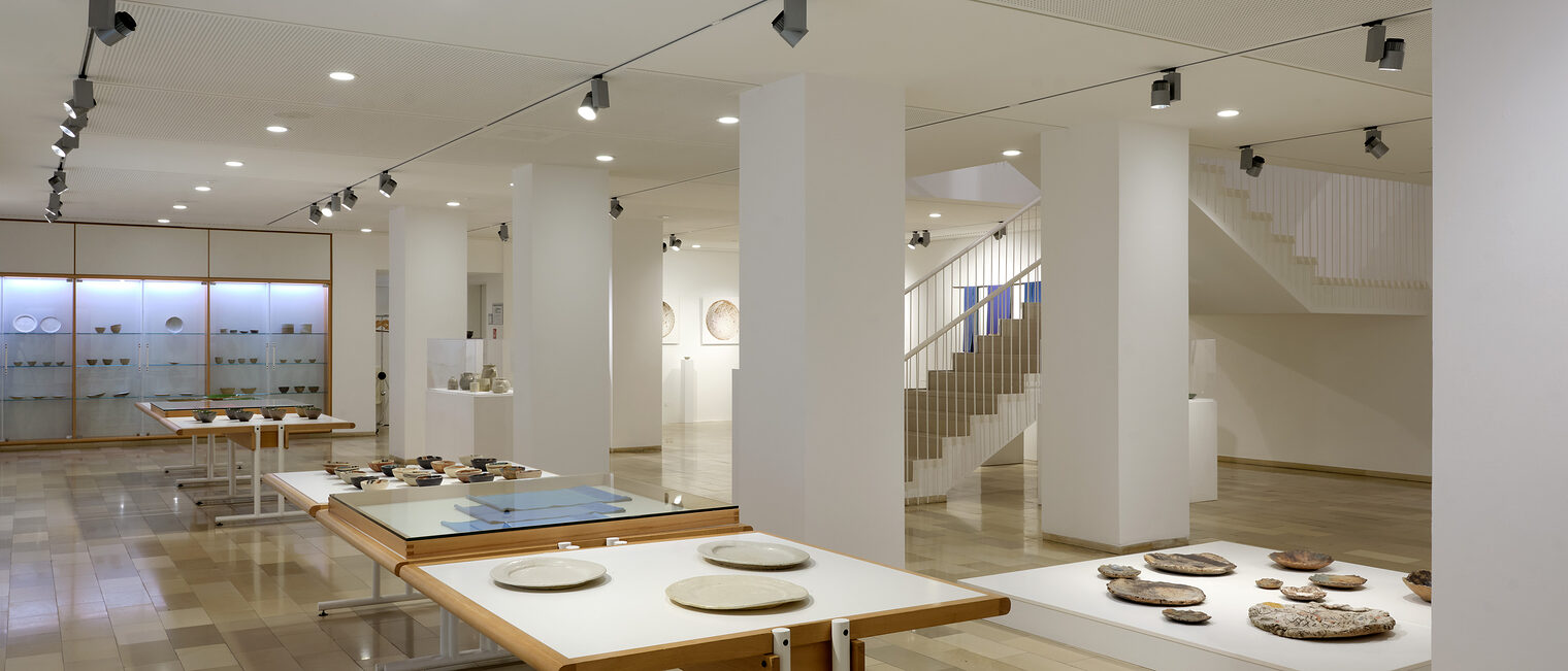 Räume der Galerie Handwerk mit Experimenten aus Ton von Renate Balda. Zu sehen sind verschiedene Teller und runde Platten.