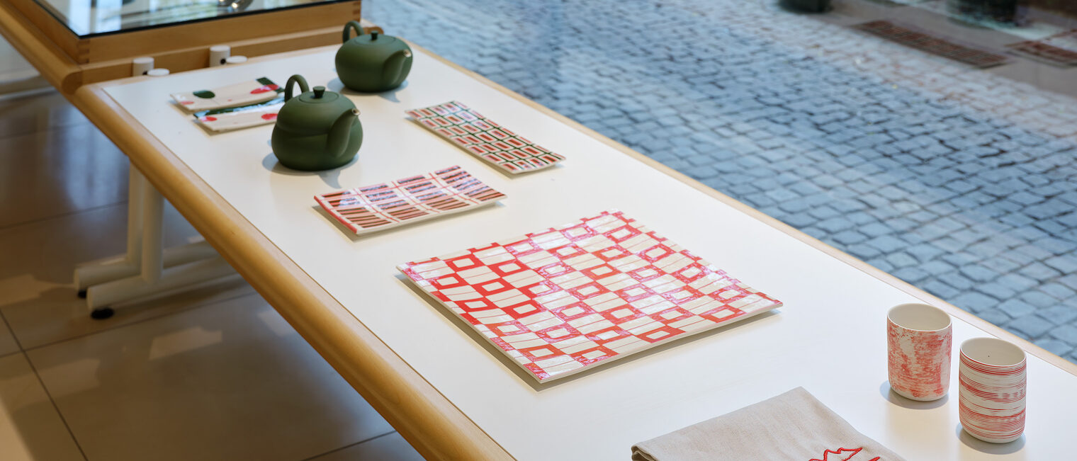 Gedeck, Teekannen, Becher, Stoffservietten auf einem Tisch mit Blick aus der Galerie Handwerk, Kunstblock München.